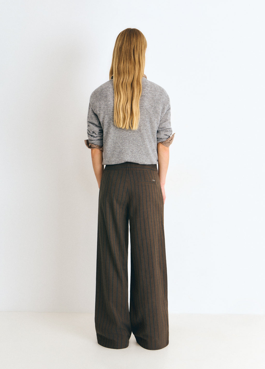 Pantalón de talle alto y corte amplio en marrón con rayas verticales, visto por detrás
