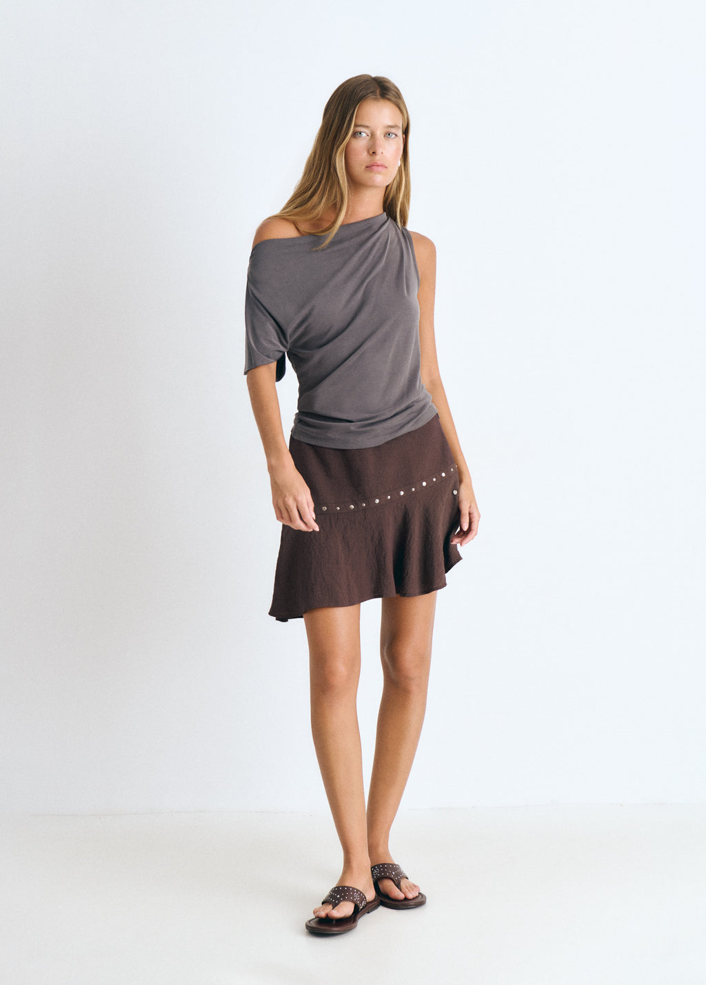 Short skirt with asymmetrical hem and studs