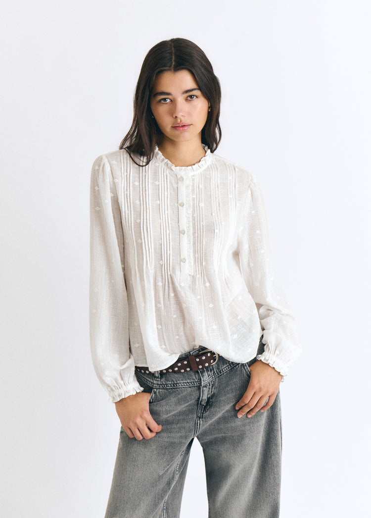 Blusa blanca de manga larga con jaretas y detalles lurex sobre modelo