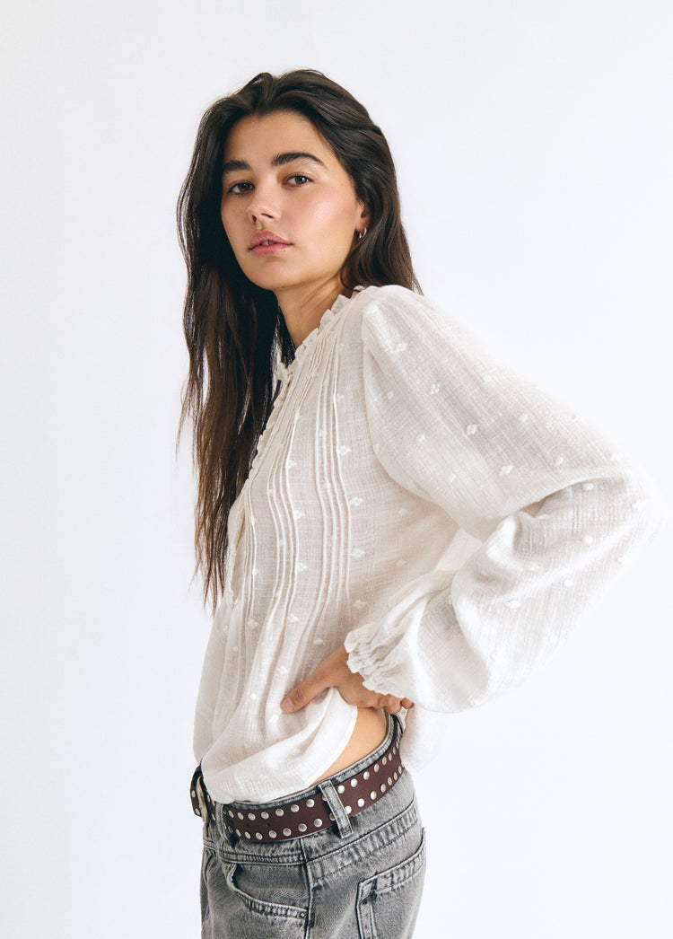 Blusa blanca de manga larga con jaretas y detalles lurex vista de perfil