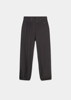 Pantalón bombacho de color antracita con cintura decorada con tachas sobre modelo