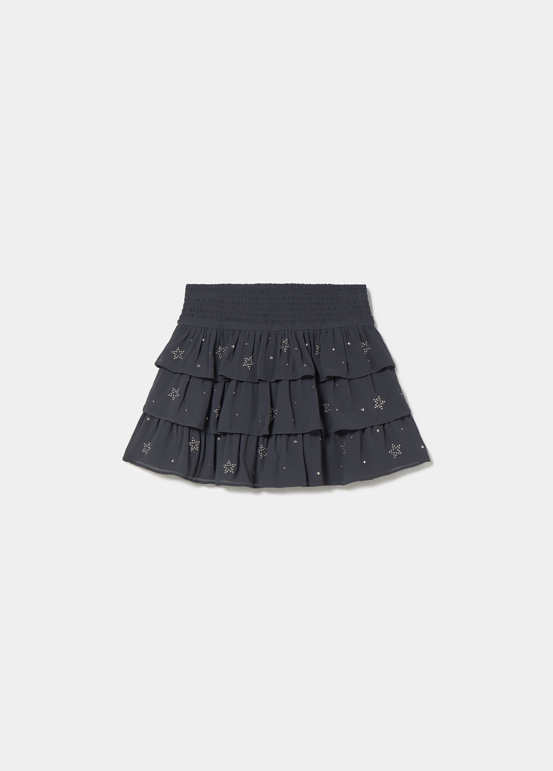 Falda corta multivolantes tachas de color plomo sobre modelo
