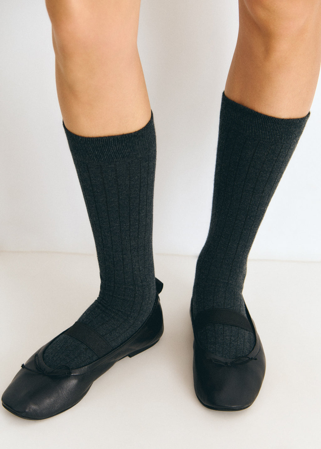 Calcetines largos de color gris sobre modelo con bailarinas negras