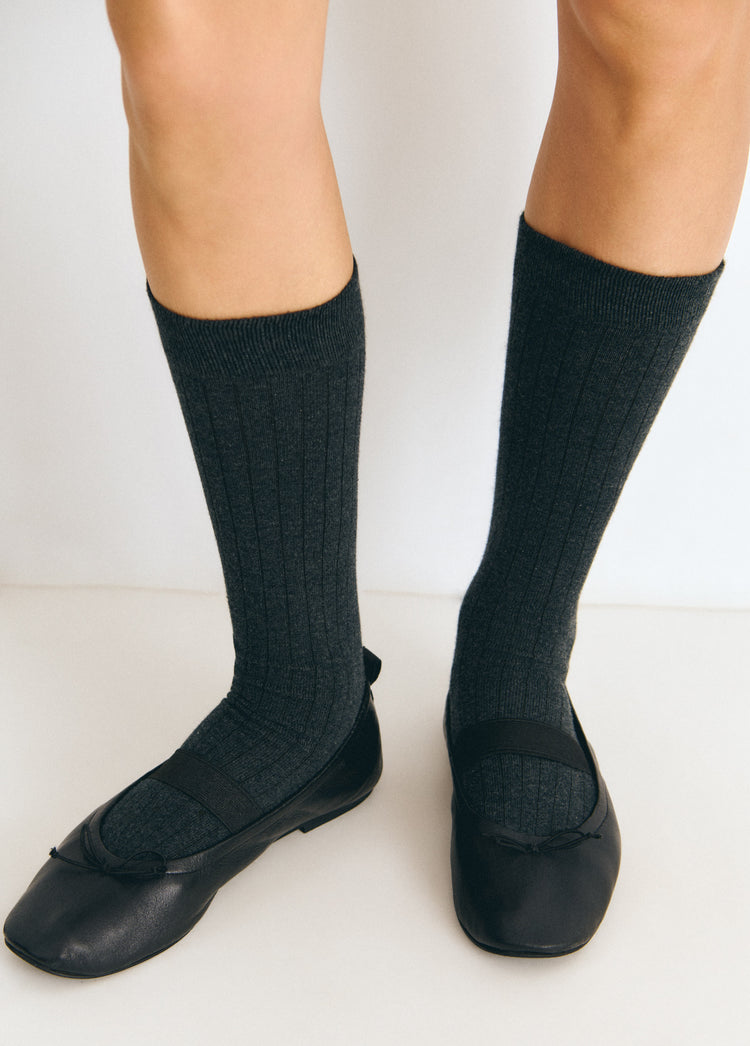 Calcetines largos de color gris sobre modelo con bailarinas negras