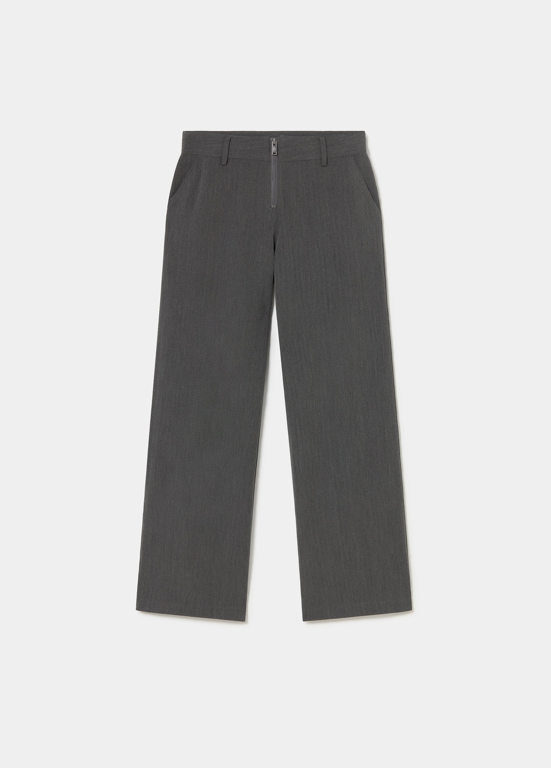 Pantalón gris de corte amplio con detalle de cremallera sobre modelo