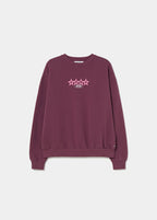 Sudadera de color granate con estampado de estrellas y texto en la espalda vista sobre modelo