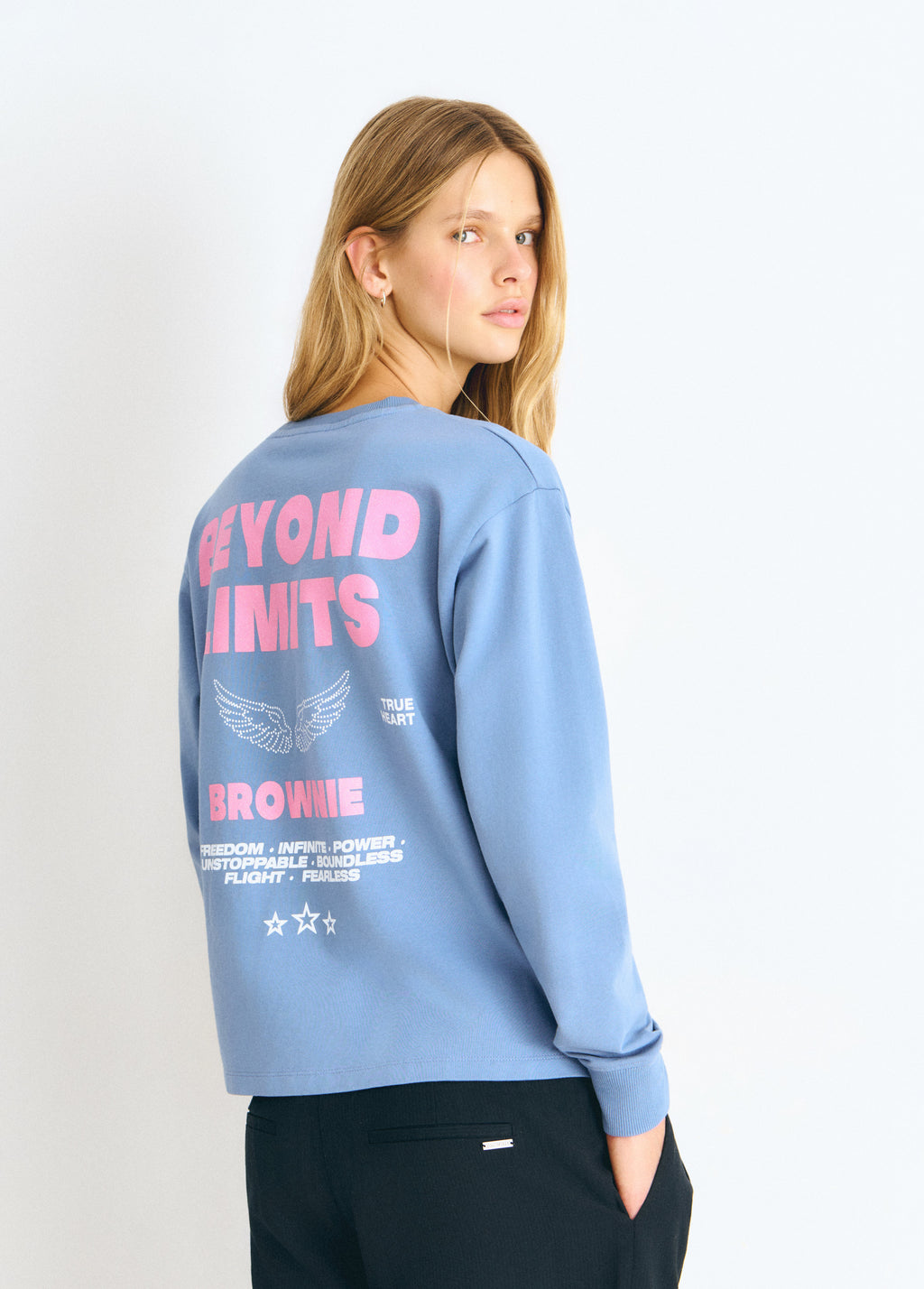 Sudadera azul vista por detrás con estampado de letras y estrellas