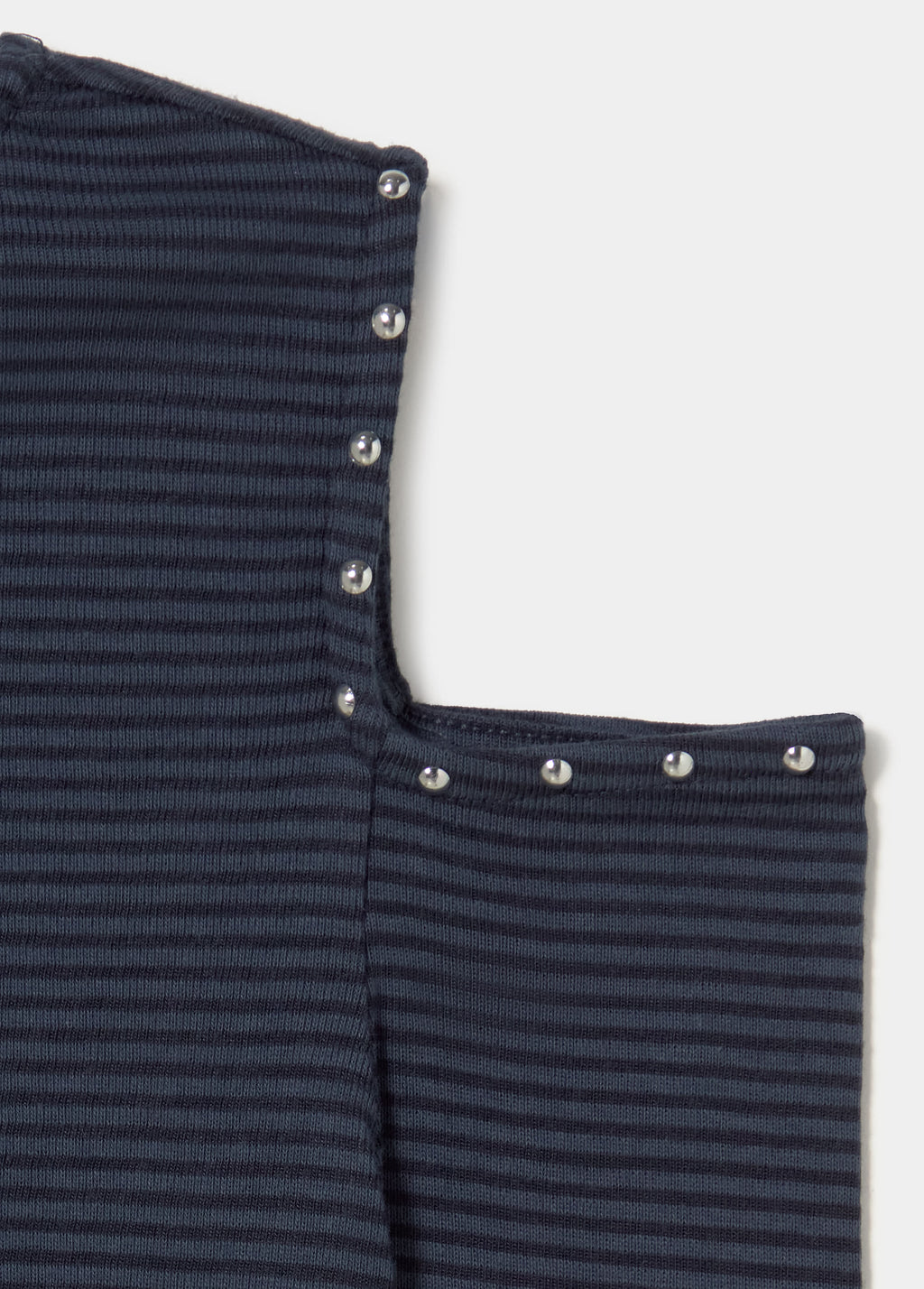 Detalle de la camiseta de rayas en azul con escote y remates de botones metálicos.