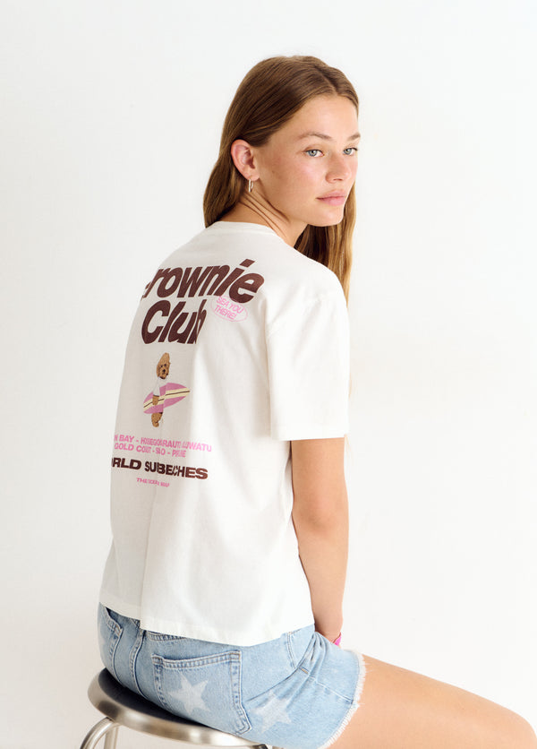 Camiseta blanca de manga corta con estampa de perro surfero y tipografía retro en la espalda