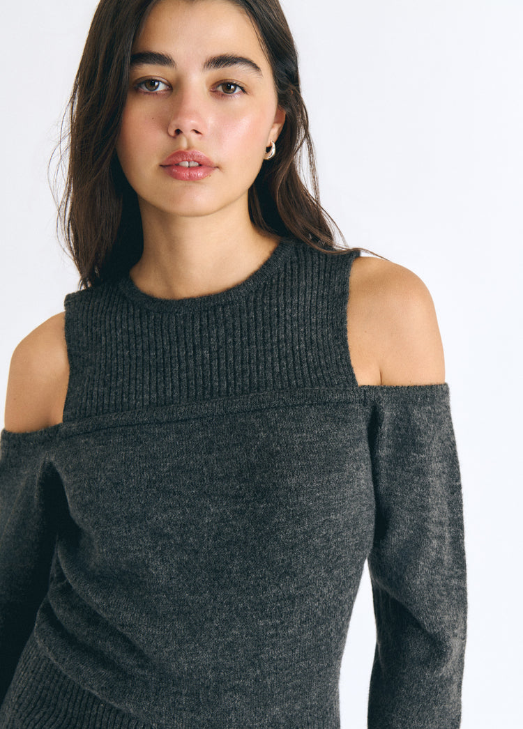 Jersey gris oscuro de cuello alto y hombros descubiertos sobre modelo