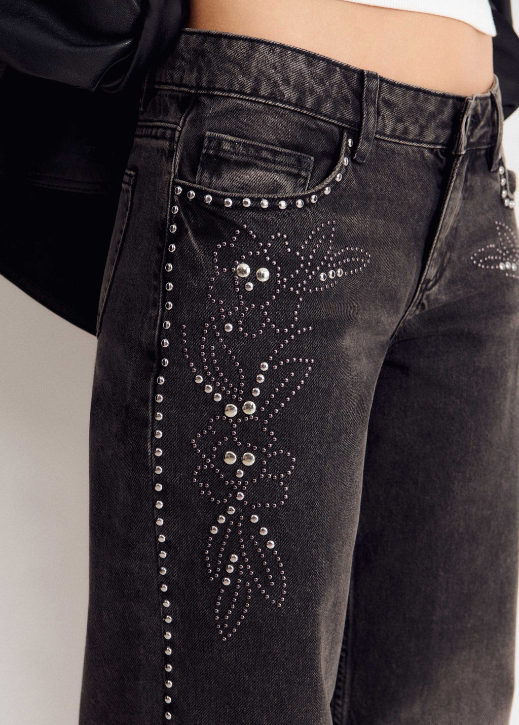 Jeans a vita bassa con borchie a forma di fiore