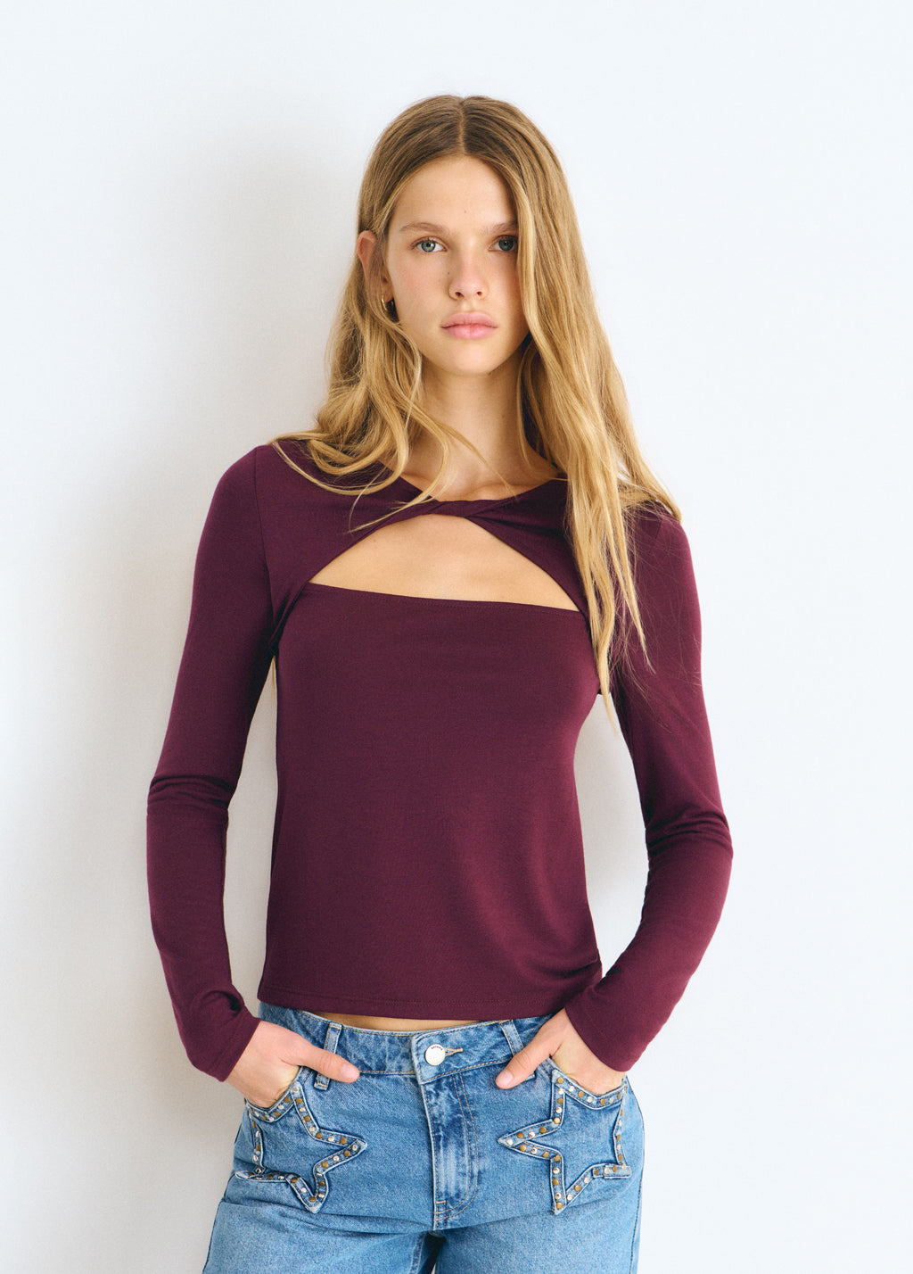 Camiseta de manga larga en granate con escote cruzado y abertura frontal sobre modelo