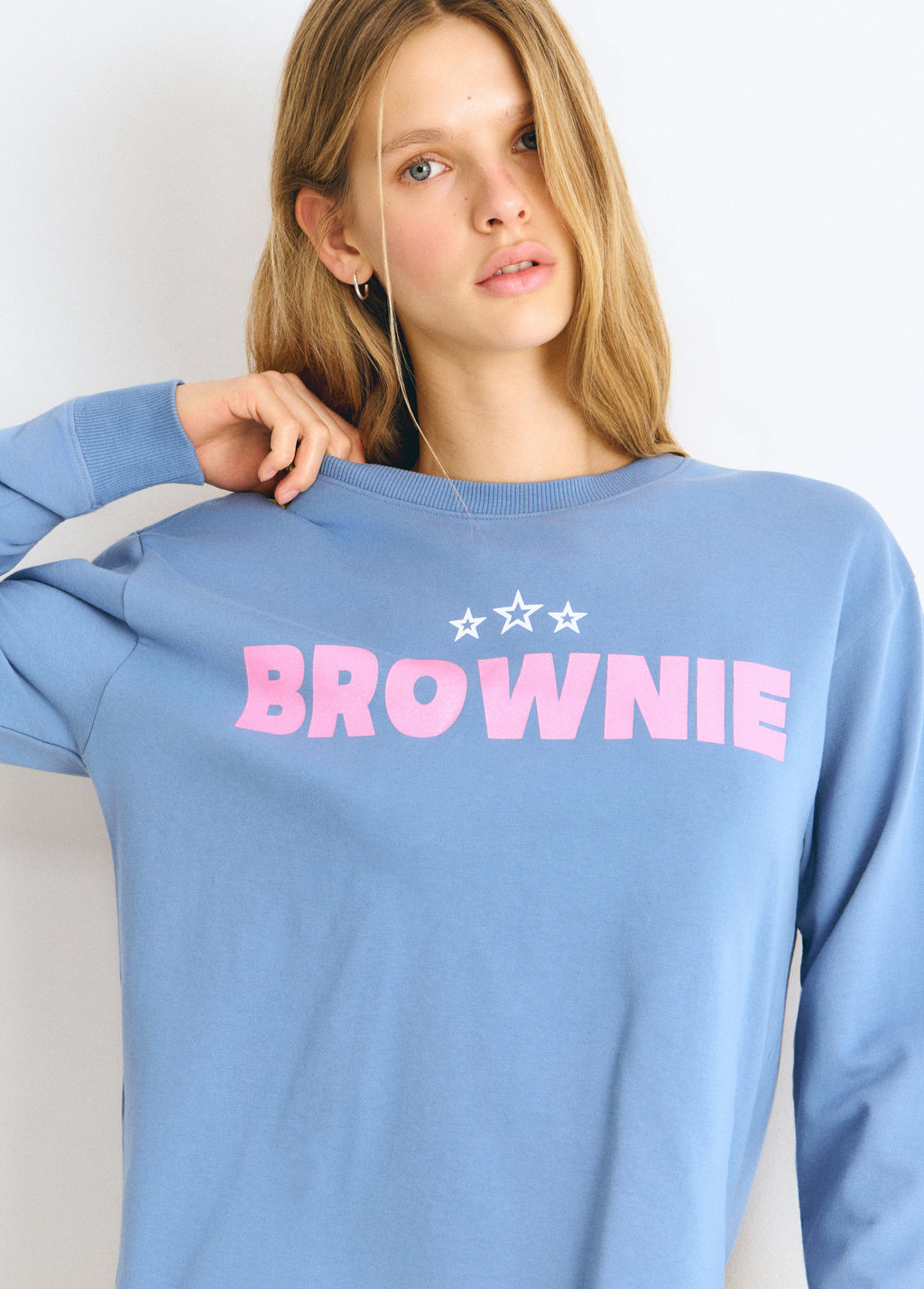 Sudadera azul con el estampado de la marca en rosa y tres estrellas blancas