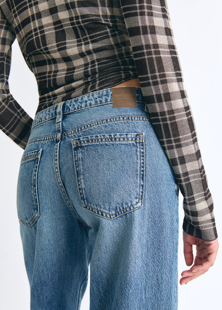 Jeans vaqueros de tiro medio y corte ancho en azul oscuro vistos por detrás sobre modelo