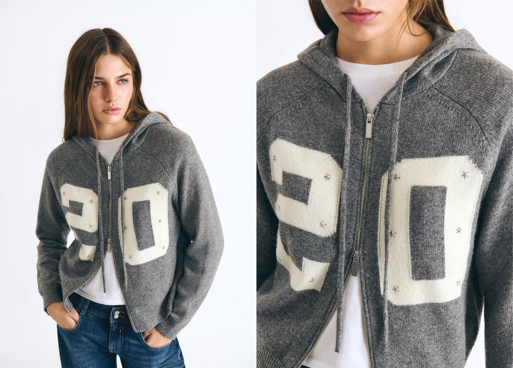 Chaqueta de punto gris con capucha y cremallera, luciendo el número 20 en blanco sobre el pecho