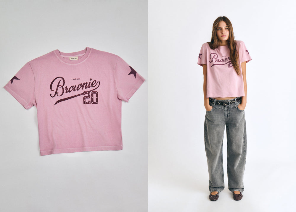 Camiseta de manga corta en tono rosado con estampado de aniversario sobre modelo