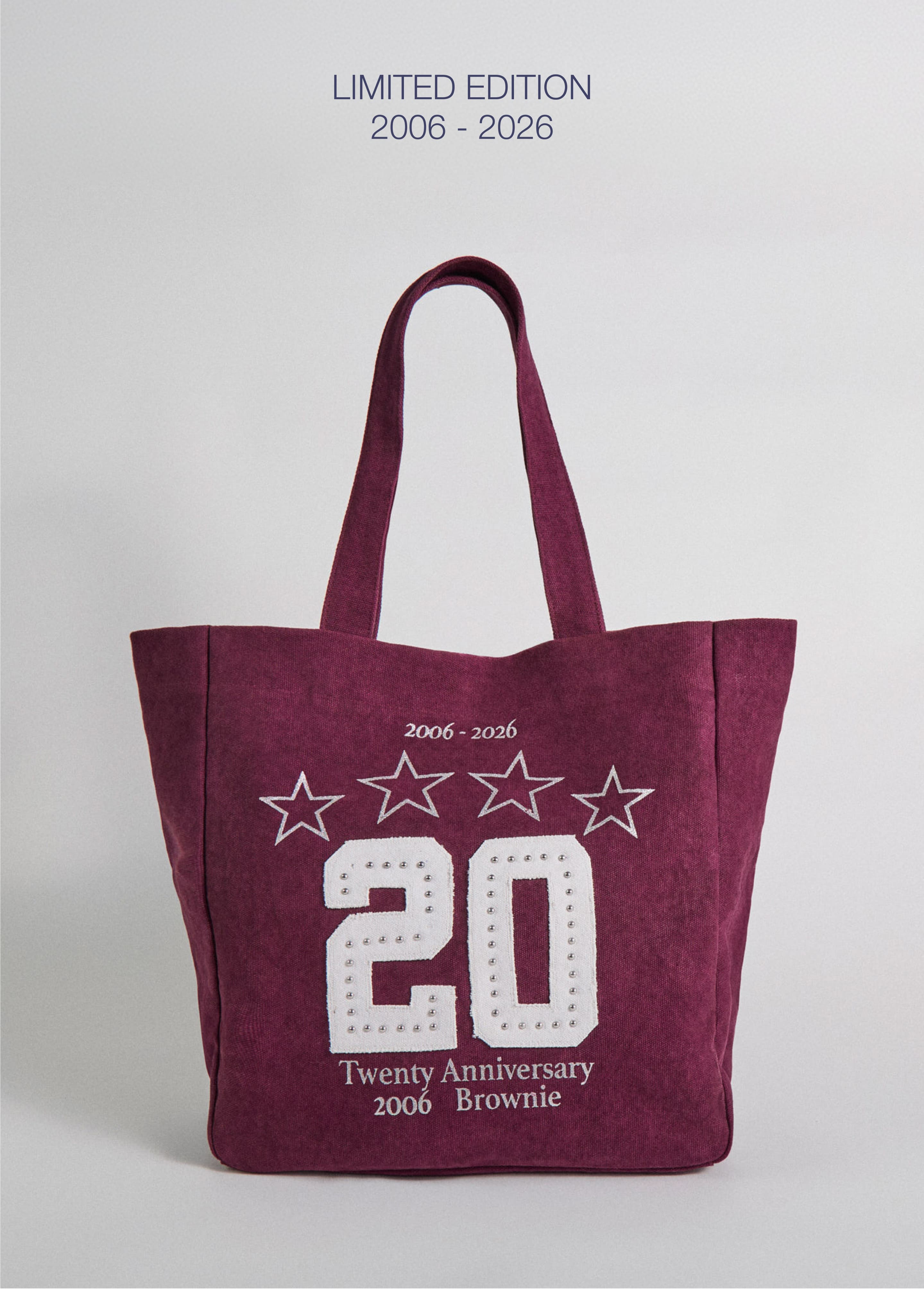 Bolso tote de lona en color granate con estampado de veinte aniversario sobre modelo